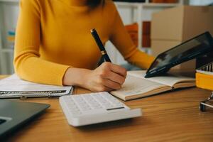 jonge vrouw kleine ondernemer online winkelen thuis. het noteren van bestellingen van klanten met mobiele telefoons. MKB ondernemer of freelance levensstijlconcept. foto