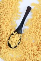 droog macaroni pasta Aan zwart lepel foto