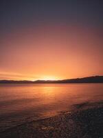 zon instelling en verlichting omhoog de oceaan en strand. foto