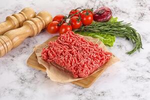 rauw fijngehakt rundvlees vlees Aan snijdend bord foto