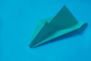 geel origami vlak Aan een blauw achtergrond. foto