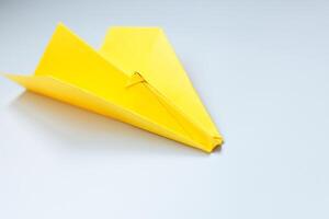 geel origami vlak Aan een wit achtergrond. foto