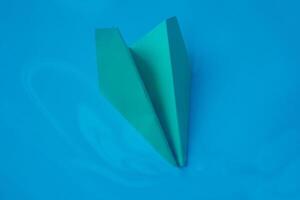 geel origami vlak Aan een blauw achtergrond. foto