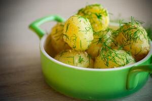 gekookt vroeg aardappelen met boter en vers dille in een kom foto