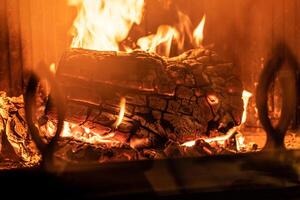 log van hout brandend in een haard binnen een huis, haard foto