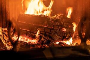 log van hout brandend in een haard binnen een huis, haard foto