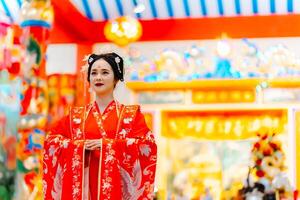 vrouw jurk China nieuw jaar. portret van een vrouw. persoon in traditioneel kostuum. vrouw in traditioneel kostuum. mooi jong vrouw in een helder rood jurk en een kroon van Chinese koningin poseren. foto