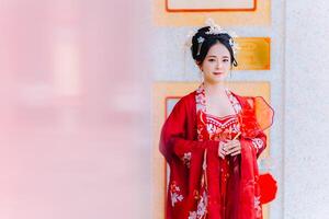 vrouw jurk China nieuw jaar. portret van een vrouw. persoon in traditioneel kostuum. vrouw in traditioneel kostuum. mooi jong vrouw in een helder rood jurk en een kroon van Chinese koningin poseren. foto