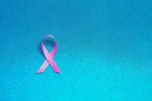 roze lint voor borst kanker bewustzijn, symbolisch boog kleur verhogen bewustzijn Aan mensen leven met vrouwen borst tumor ziekte. boog geïsoleerd met knipsel schitteren blauw achtergrond foto