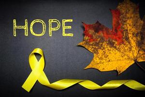 kinderjaren kanker bewustzijn dag. geel lint Aan zwart achtergrond. foto