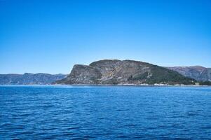 western pet in Noorwegen. een berg bereiken in de fjord. blauw lucht. landschap foto