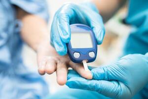 dokter controleren diabetes van vinger bloed suiker niveau met vinger lancet. foto