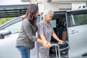 Aziatisch senior vrouw geduldig zittend Aan wandelaar bereiden krijgen naar haar auto, gezond sterk medisch concept. foto