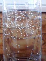 getextureerde effect van bubbels Aan een glas met mineraal water foto