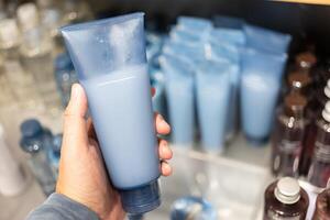 room in een buis Aan hand- Bij kunstmatig op te slaan. dermatoloog handen Holding blanco kunstmatig huidsverzorging fles. schuim dispenser voor gezicht zorg. houder met lichaam lotion. foto