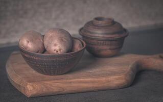 aardappelen in een klei bruin bord en twee potten. filmische foto