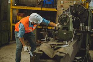 industrie mannetje ingenieur arbeider veiligheid controleren machine onderhoud fix opstelling werken in draaibank staal metaal fabriek foto