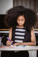 schattig Afrikaanse zwart afro tiener aandacht aan het leren onderwijs Bij huis foto