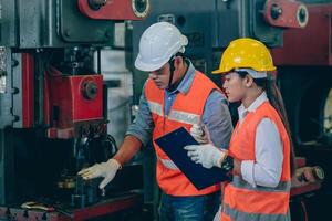 ingenieur mannetje opleiding en controleren machine met vrouw arbeider team in metaal industrie fabriek foto