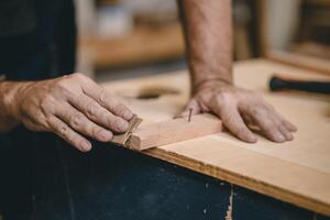 professioneel timmerman schrijnwerker hand- gebruik zand papier maken meubilair. huis bouwer diy projecten authentiek handgemaakt hout arbeider. foto