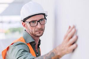 bouwer arbeider kijken Bij bouw bepleistering muur voor hoog precisie detail en kwaliteit voor mooi zo huis bouwen foto