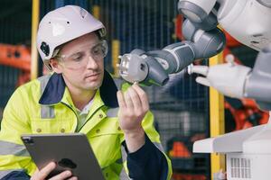 professioneel ingenieur mannetje Kaukasisch werken met geautomatiseerd robot arm voor modern industrie fabriek technologie foto