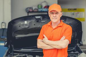 portret volwassen garage monteur personeel arbeider staand glimlach voor professioneel motor onderhoud auto zorg foto