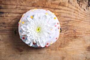 chrysant knop Aan top van donut Aan houten achtergrond. delicaat kader met wit bloem foto