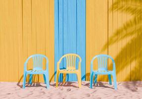 kleurrijk plastic stoelen tegen geel en blauw houten muur Aan zand foto