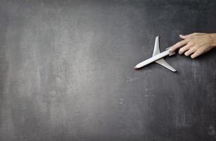 speelgoed- vliegtuig over- een grijs leeg bord sjabloon, toeristisch reizen concept achtergrond foto