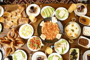 overvloedig houten tafel weergeven verscheidenheid van heerlijk voedsel foto
