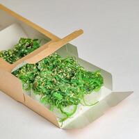 karton doos gevulde met groen groenten Aan tafel foto