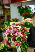 vrouw Holding boeket van bloemen in bloem winkel foto