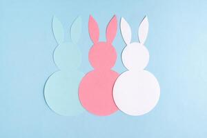 Pasen concept. drie papier konijnen Aan een blauw achtergrond. Pasen achtergrond. foto