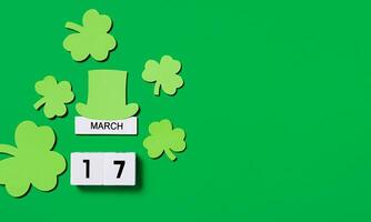 st. Patrick dag concept. houten kalender met klavers en kabouter hoed Aan een groen achtergrond. banier kopiëren ruimte. foto