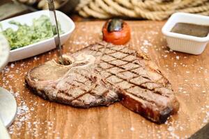 gesneden steak Aan snijdend bord met salade kom foto