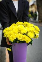 vrouw Holding Purper vaas met geel bloemen foto