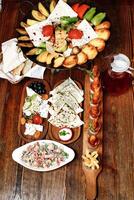 overvloedig houten tafel Laden met divers heerlijk voedingsmiddelen foto