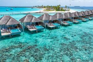 perfect antenne landschap, luxe tropisch toevlucht met water villa's. mooi eiland strand, palm bomen, zonnig lucht. verbazingwekkend vogel ogen visie in Maldiven, paradijs kust. exotisch toerisme, kom tot rust natuur zee foto