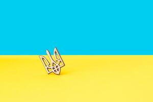 drietand symbool van Oekraïne ijzer insigne Aan de achtergrond van de blauw Geel vlag foto
