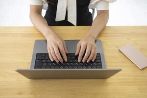 een Japans vrouw typen laptop door afgelegen werk in de kantoor gezichtsloos samenstelling foto