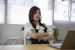 een bezorgd Japans vrouw door afgelegen werk in de klein kantoor foto