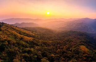 zonsopkomst over- berg reeks in tropisch regenwoud Bij phu lom kijk, phu hin rong kla nationaal park foto