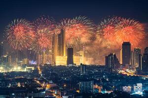 nieuw jaar festival met vuurwerk Scherm gloeiend over- afdeling op te slaan, verlichte gebouw in downtown gedurende middernacht tijd Bij Bangkok, Thailand foto