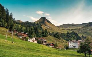 berg dorp van stoos omringd door Zwitsers Alpen, in zomer Bij schwyz, Zwitserland foto