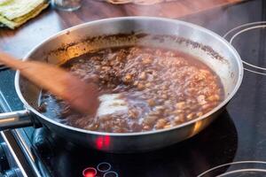 houten flipper kauwen zoet saus met knoflook Aan koekepan foto