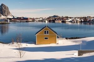 geel huis Aan sneeuw in visvangst dorp Aan kustlijn foto