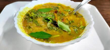 traditioneel zuiden Indisch tussendoortje dal sambhar soep met kerrie bladeren foto