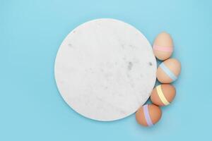 marmeren cirkel met versierd eieren Aan blauw achtergrond foto