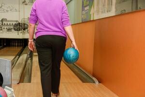 vrouw met bal wandelen naar bowling steeg foto